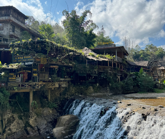 best places to visit in Vietnam, Sapa cat cat village with waterfall and wooden buildings