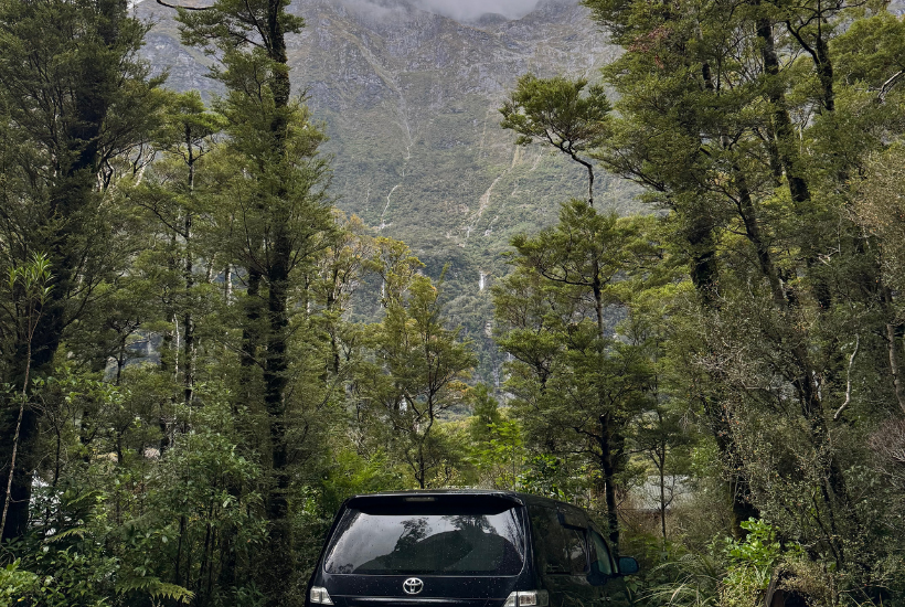 Milford Sound lodge campsite with views of mountains with streams running down and trees