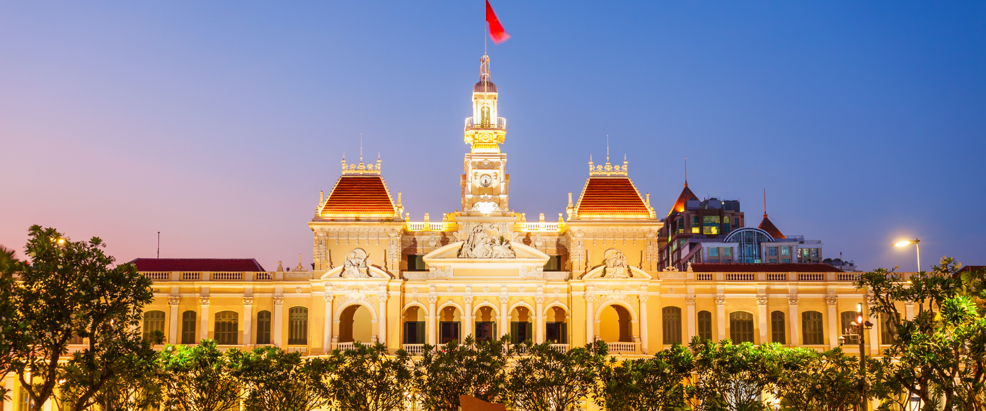 Ho Chi Minh city at night, building with Vietnam flag flying